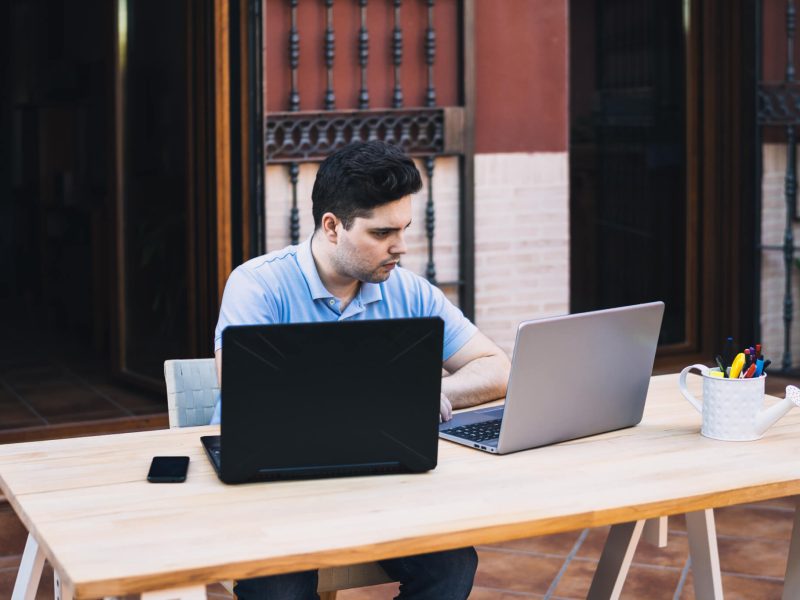 man-teleworking-with-two-laptops-trading-in-cryptocurrencies.jpg